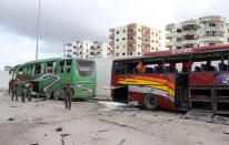 Syrians soldiers inspect damaged buses at the scene where suicide bombers blew themselves up in the coastal town of Tartus, Syria, on May 23, 2016. (SANA via AP)