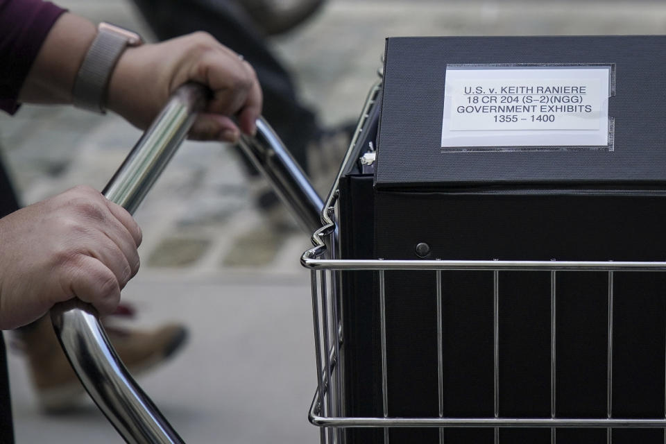 a close up photo of a woman&#39;s hands pushing a trolley full of court documents related to the U.S. v. Keith Raniere case at the U.S. District Court for the Eastern District of New York a, May 7, 2019 in the Brooklyn borough of New York City.