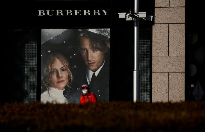 A woman walks past a Burberry boutique in Beijing, China