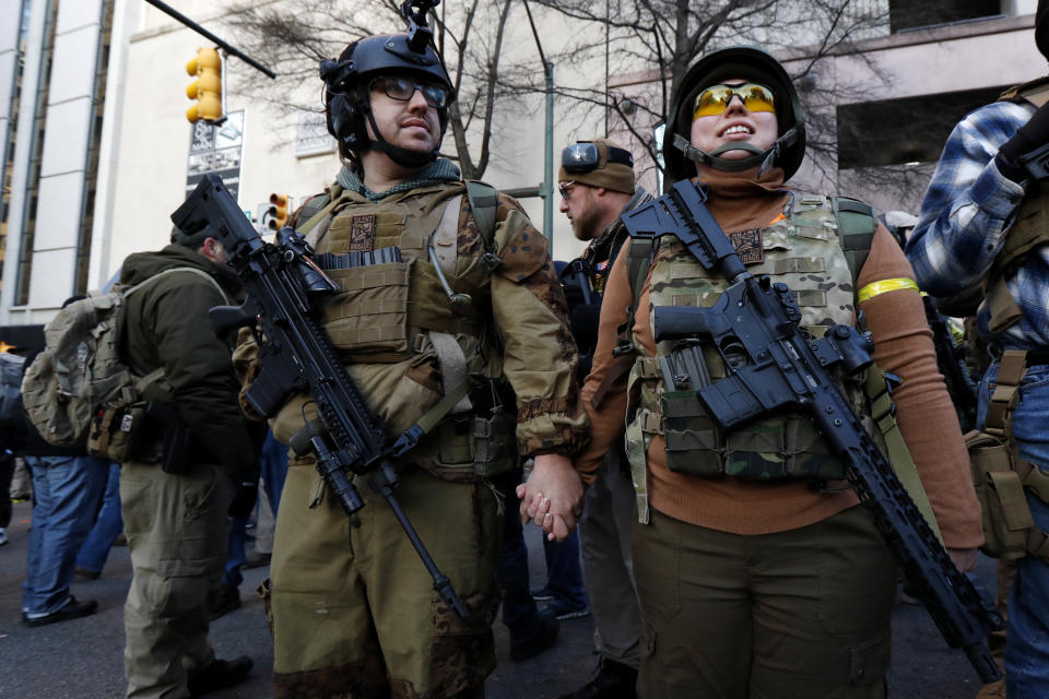 FILE - In this Jan. 20, 2020 file photo, demonstrators stand outside a security zone before a pro-gun rally in Richmond, Va. Gov. Ralph Northam announced Friday, April 10 that he'd signed bills that include requiring universal background checks on gun purchases, a red flag bill to allow authorities to temporarily take guns away from people deemed to be dangerous to themselves or others, and legislation giving local governments more authority to ban guns in public places. (AP Photo/Julio Cortez, File)