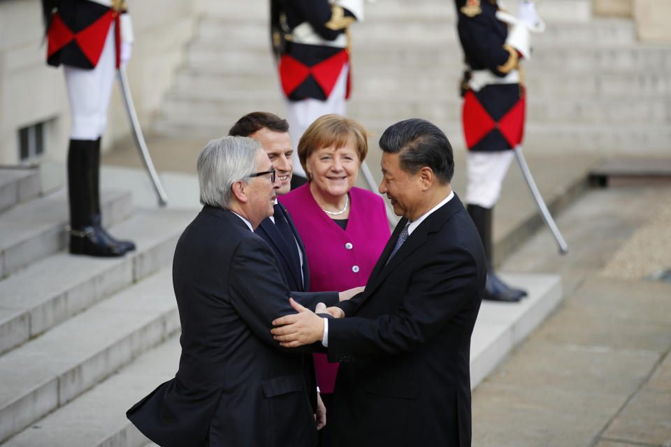 Chinese President Xi Jinping, is welcomed by French President Emmanuel Macron, 2nd right, with German Chancellor Angela Merkel, right, and European Commission President Jean-Claude Juncker, left, prior to their meeting at the Elysee presidential palace in Paris, Tuesday, March 26, 2019. Merkel and Juncker are meeting with Macron as they prepare for a possibly chaotic Brexit and a crucial summit with China. (AP Photo/Francois Mori)