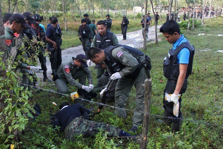 Police inspect the bodies of suspected insurgents who were killed when they attacked a military base in Thailand's restive southern province of Narathiwat on February 13, 2013. Scores of heavily armed gunmen stormed the military base, an army spokesman said, in a major assault that left at least 16 militants dead
