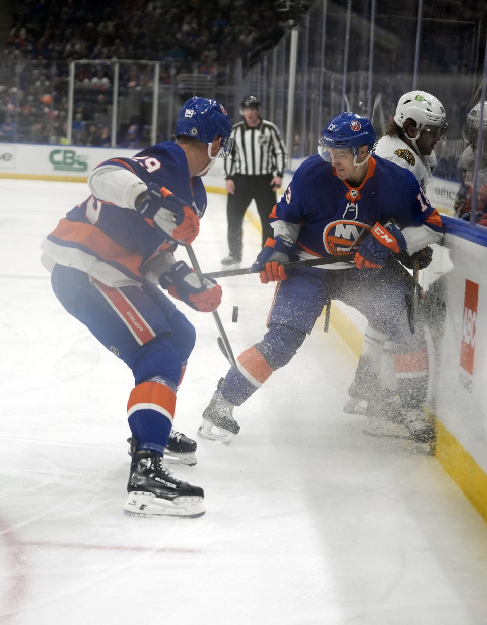 New York Islanders center Mathew Barzal (13) checks Boston Bruins right wing David Pastrnak, rear, during the first period of an NHL hockey game in Elmont, N.Y., Saturday, March 2, 2024. (AP Photo/Peter K. Afriyie)