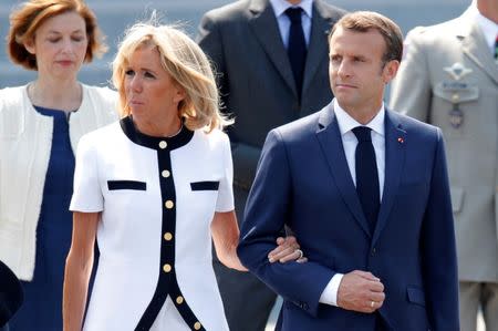 French President Emmanuel Macron and his wife Brigitte Macron leave after the traditional Bastille Day military parade on the Champs-Elysees Avenue in Paris, France, July 14, 2018. REUTERS/Charles Platiau