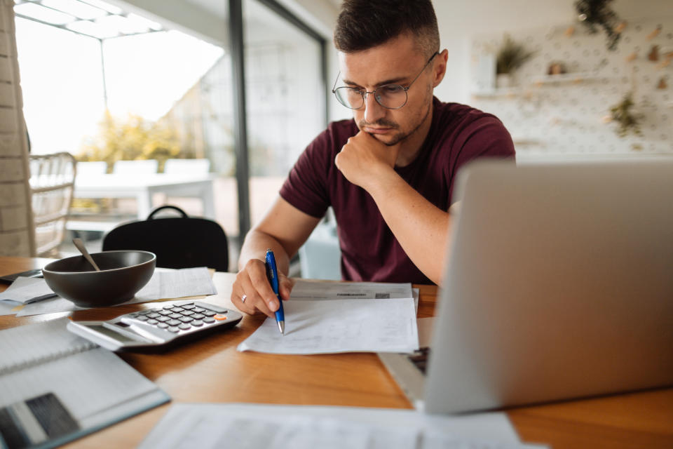 Young man at home, paying bills online