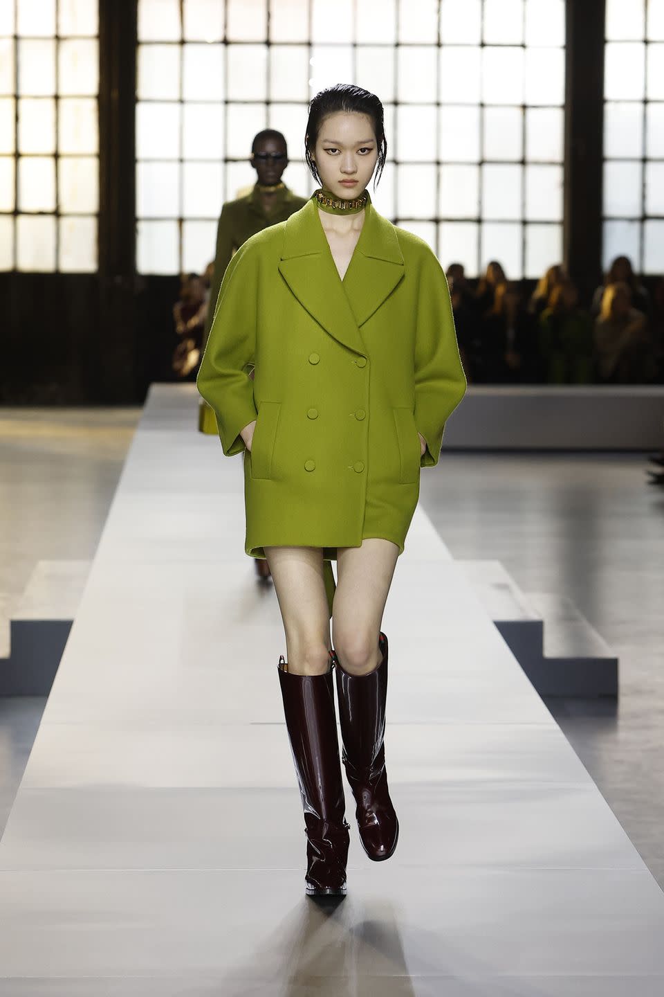 a person wearing a green coat and boots
