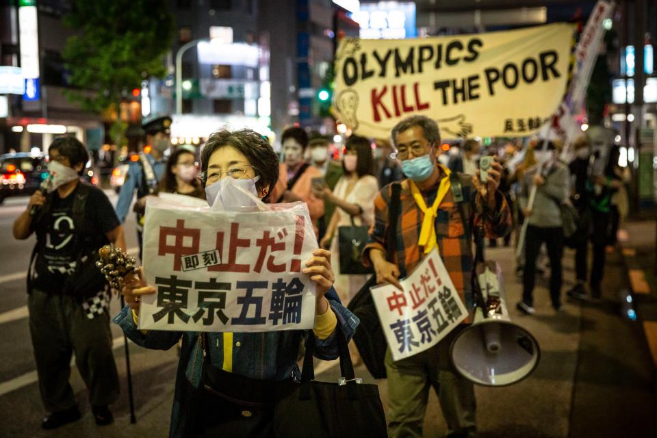 Protesters carry placards as they demonstrate against the Tokyo Olympics.