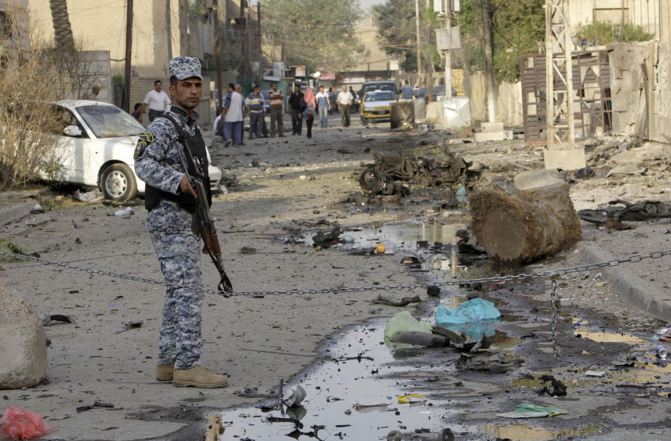 FILE - In this Nov. 1, 2010 file photo, an Iraqi policeman stands guard at the scene of a car bomb attack in front of a Syrian Catholic Church, in Baghdad, Iraq. Islamic militants held around 120 Iraqi Christians hostage for nearly four hours in a church Sunday before security forces stormed the building and freed them, ending a standoff that left dozens of people dead, U.S. and Iraqi officials said. (AP Photo/Khalid Mohammed)