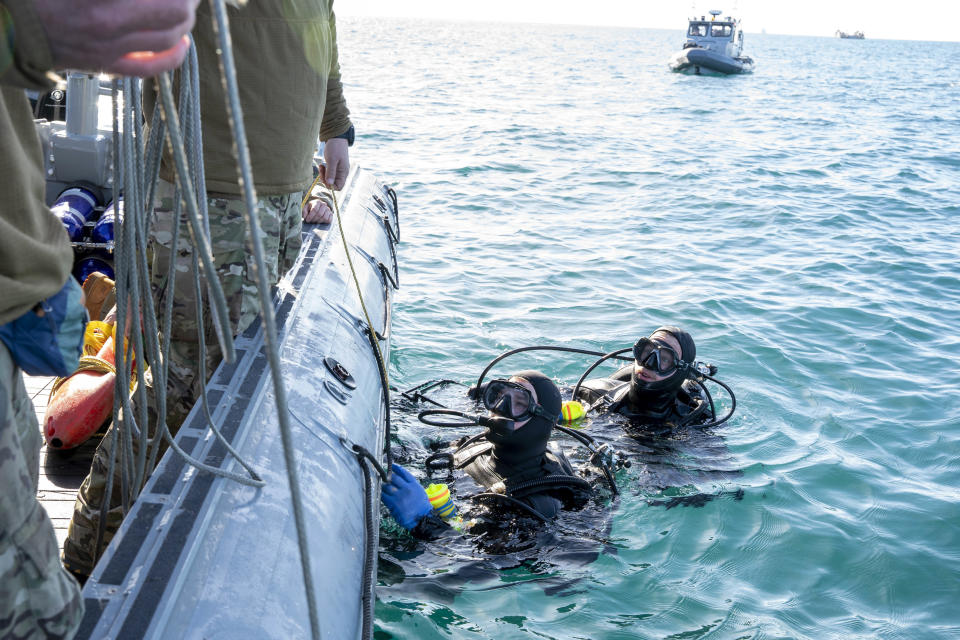 In this image provided by the U.S. Navy, sailors assigned to Explosive Ordnance Disposal Group 2, conduct pre-dive checks during recovery efforts for debris from a Chinese high altitude balloon in the Atlantic Ocean, off the coast of Myrtle Beach, S.C., Feb. 7, 2023. (Ryan Seelbach/U.S. Navy via AP)