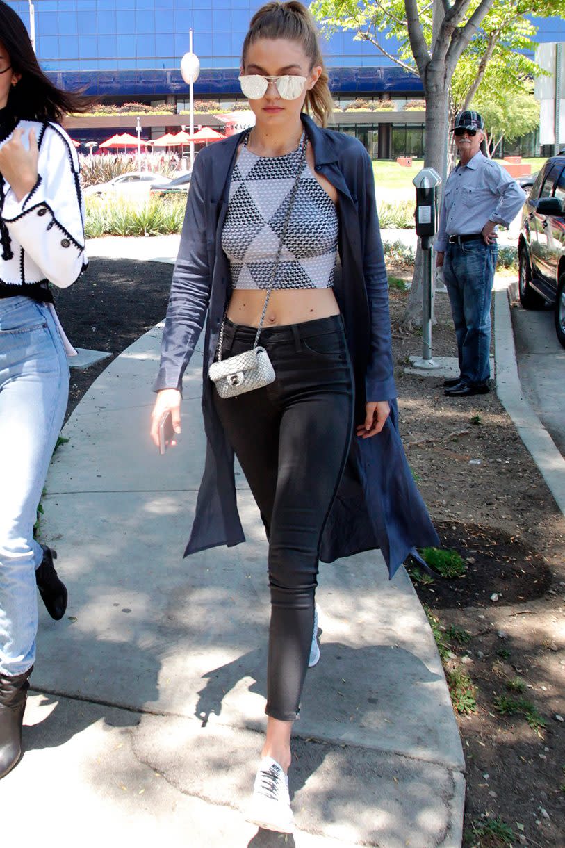 <p>Un jean slim noir, un crop top, une veste longue : il n’en faut pas plus à Gigi pour sortir de chez elle. Crédit : Getty </p>