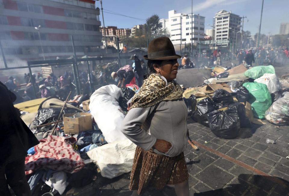 A woman takes part in a cleanup effort in the aftermath of violent protests against the government, in Quito, Ecuador, Monday, Oct. 14, 2019. Ecuador celebrated a deal President Lenín Moreno and indigenous leaders struck late Sunday to cancel a disputed austerity package and end nearly two weeks of protests that have paralyzed the economy and left seven dead. (AP Photo/Fernando Vergara)