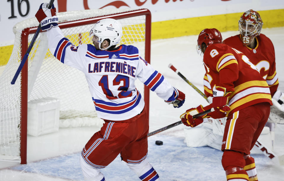 New York Rangers forward Alexis Lafreniere, left, celebrates his goal on Calgary Flames goalie Jacob Markstrom during the second period of an NHL hockey game Tuesday, Oct. 24. 2023, in Calgary, Alberta. (Jeff McIntosh/The Canadian Press via AP)