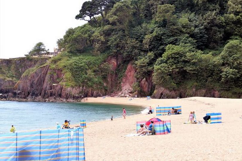 Sunbathers on Blackpool Sands, Devon, UK.