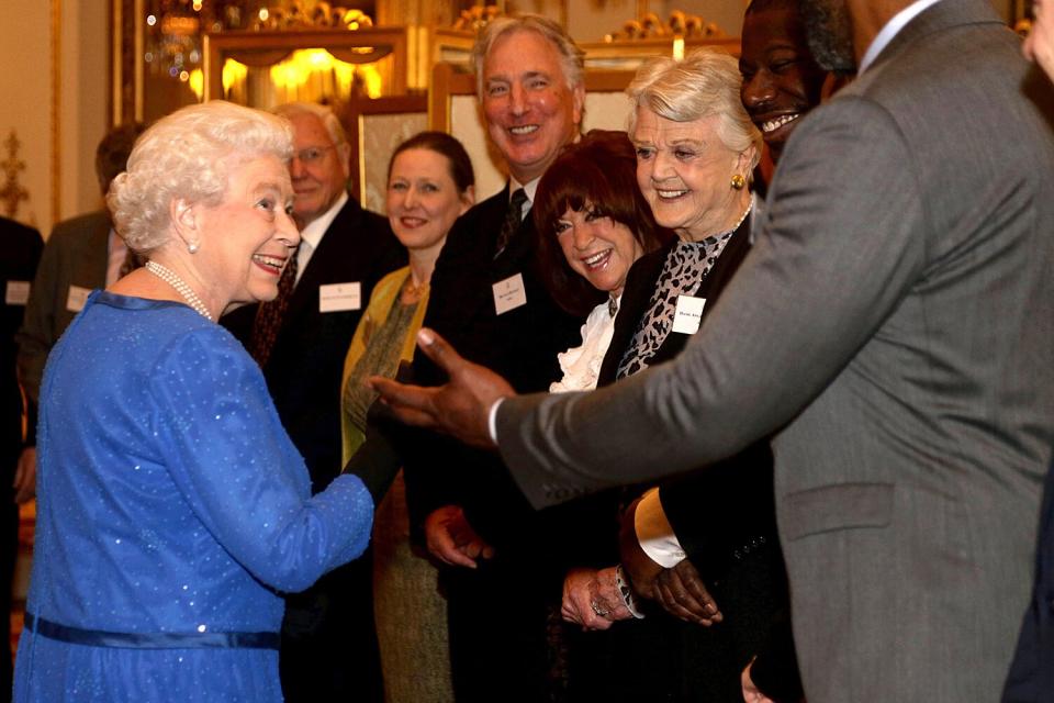 Queen Elizabeth II meets guests, including (L-R) Lenny Henry, Steve McQueen, Lynda La Plante, Dame Angela Lansbury and Alan Rickman during the Dramatic Arts reception at Buckingham Palace