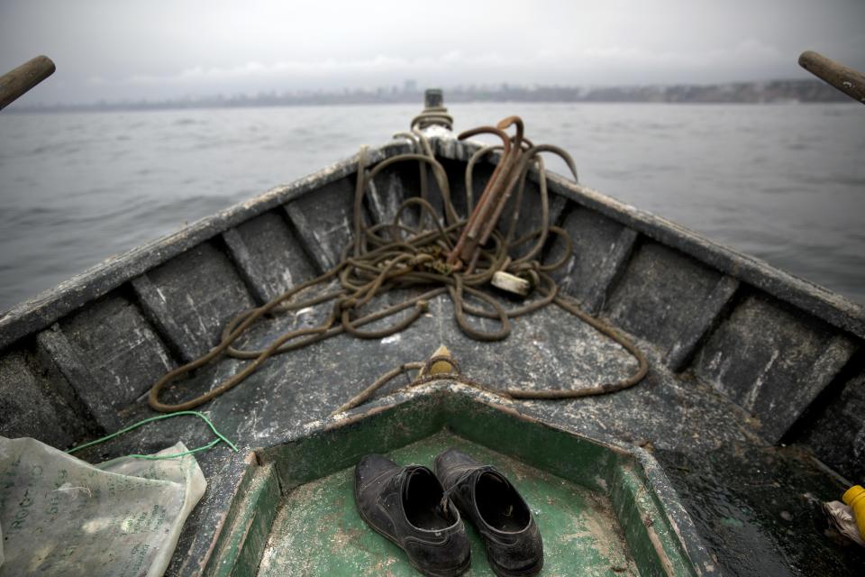 <p>The shoes of small-scale fisherman Alvaro del Carmen, 51, are seen on the deck of his boat near Chorrillos harbor in Lima, Peru, on Sept. 23, 2015. (Photo: Rodrigo Abd/AP) </p>