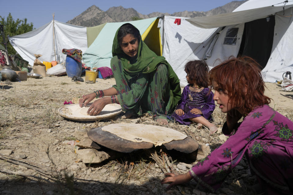 Afghans prepare food in a camp after an earthquake in Gayan district in Paktika province, Afghanistan, Sunday, June 26, 2022. A powerful earthquake struck a rugged, mountainous region of eastern Afghanistan early Wednesday, flattening stone and mud-brick homes in the country's deadliest quake in two decades, the state-run news agency reported. (AP Photo/Ebrahim Nooroozi)