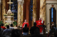 El reverando Rick Beuther (con los brazos en alto) ofrece una misa en español el lunes 6 de julio del 2020, en que la iglesia San Bartolomeo de Nueva York reabrió sus puertas tras un cierre motivado por la pendemia del coronavirus. (AP Photo/John Minchillo)