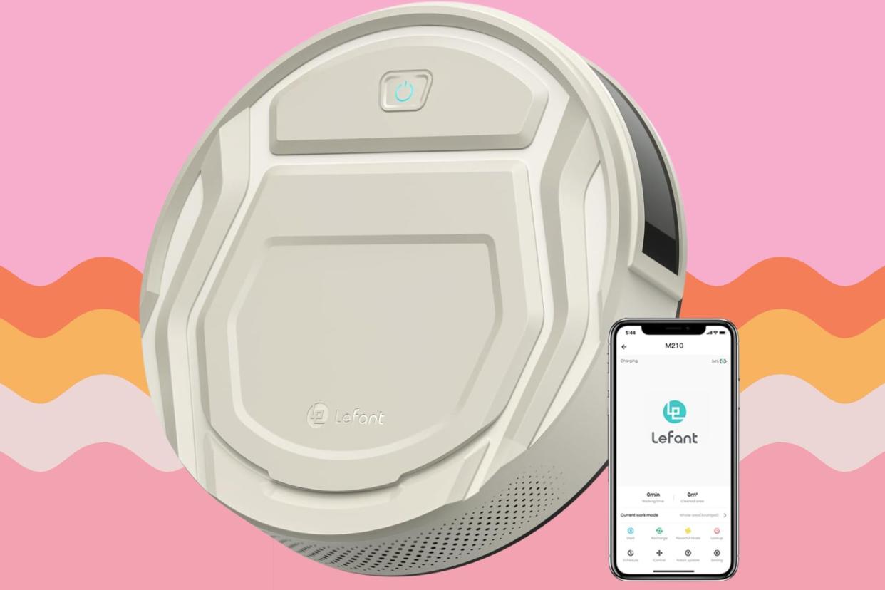 the Amazon robot vacuum and a phone with the correlating app open