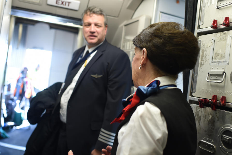 American Airlines longest serving flight attendant, Bette Nash (R), 81 years old, chats with the Captain before disembarking from her daily return flight to Boston at Ronald Reagan Washington Airport in Arlington, Virginia on December 19, 2017.   American Airlines Flight 2160 from Boston has just arrived in Washington, D.C., and Bette Nash, 81, helps the passengers disembark. After six decades crossing the skies as a flight attendant, Nash still has impeccable style, incredible energy and a constant smile. In the United States, pilots must retired at 65 but there is no such restriction on commercial flight attendants, of which Bette Nash is probably the world's most senior. / AFP PHOTO / Eric BARADAT        (Photo credit should read ERIC BARADAT/AFP via Getty Images)