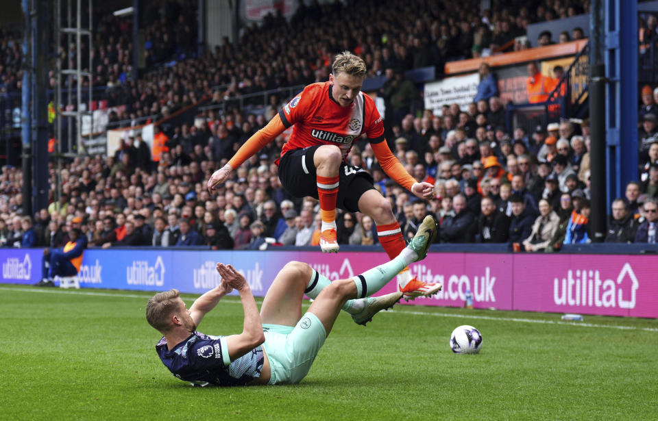 Luton Town's Alfie Doughty, right, and Brentford's Kristoffer Ajer battle for the ball during the English Premier League soccer match between Brentford FC and Luton Town at Kenilworth Road stadium, in Luton, England, Saturday April 20, 2024. (John Walton/PA via AP)