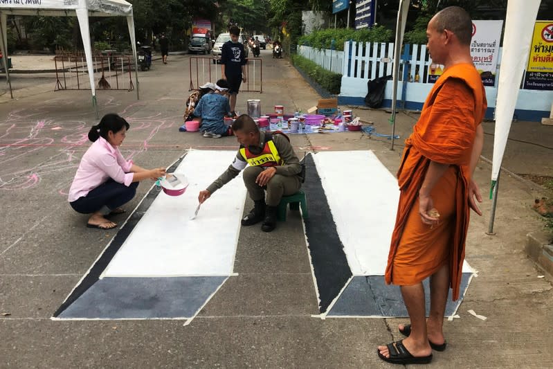 People paint a 3D pedestrian crossing in Kanchanaburi province