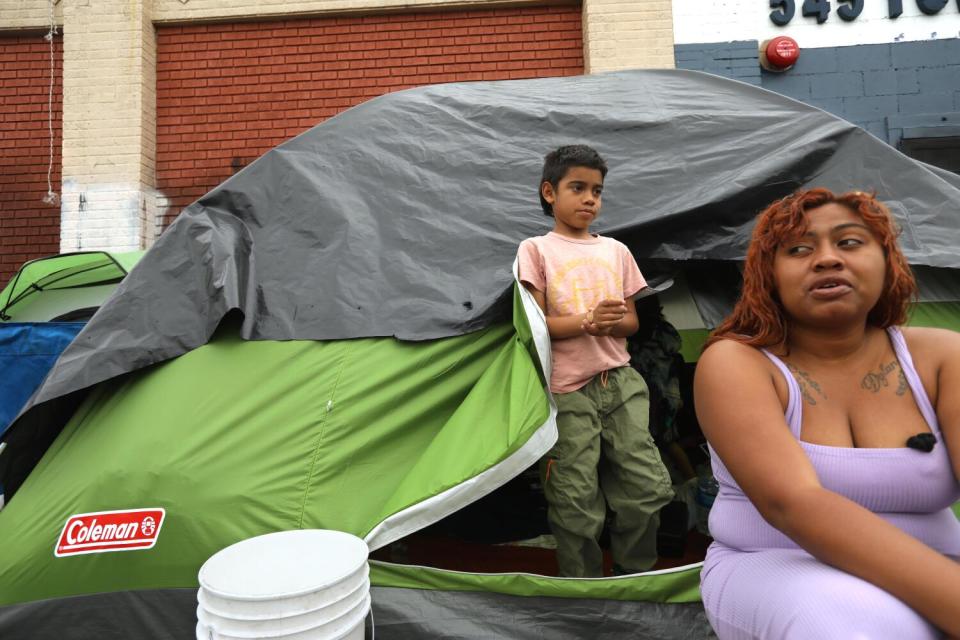 Dylan, 8, stands at the entrance to a tent he shares with his mother Jaidelin Chacon,