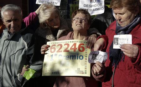 Pensioners, who won part of the first prize of Spain's Christmas Lottery "El Gordo" (The Fat One), celebrate outside a lottery shop where the lottery number was sold in Leganes, near Madrid, December 22, 2013. REUTERS/Andrea Comas