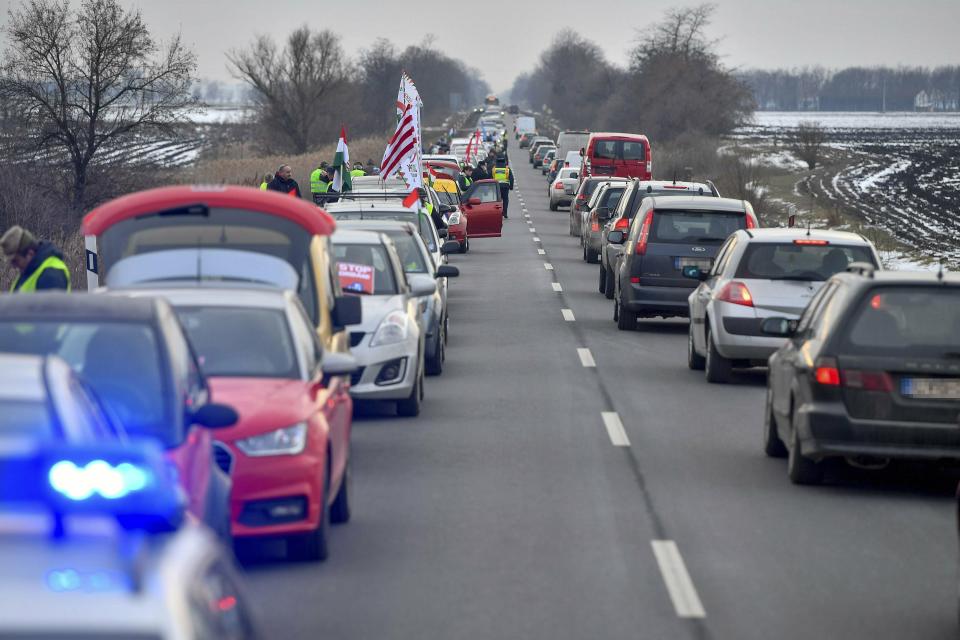 Motorists block one lane of a main road to protest against the recent amendments to the labour code, dubbed 'slave law' by opposition forces, near Debrecen, some 230 kms east of Budapest, Hungary, Saturday, Jan. 19, 2019. (Zsolt Czegledi/MTI via AP)