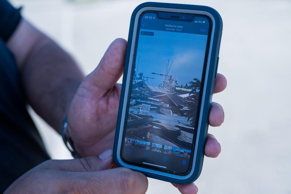 Jay Johnson, owner of Bubba's Roadhouse & Saloon and Bert's Bar & Grill, displays an image of the damage on westbound Pine Island Road towards Matlacha after Hurricane Ian passed through the region Wednesday afternoon in Cape Coral, FL., on Friday, September 30, 2022.