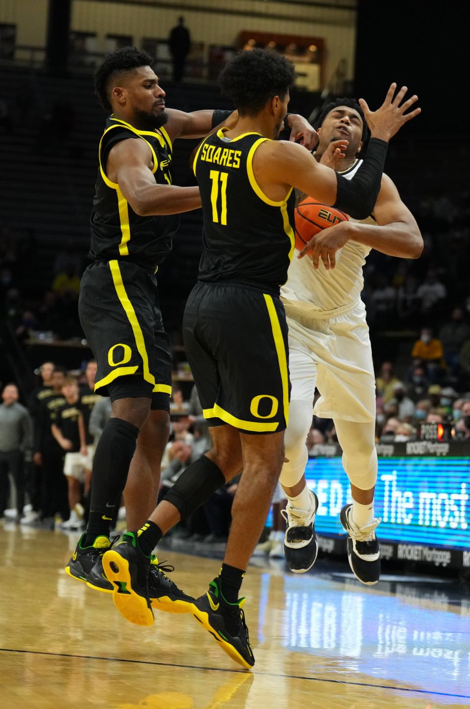 Oregon's Quincy Guerrier (13) and Rivaldo Soares (11) swarm Colorado's Evan Battey in the second half Thursday. Mandatory Credit: Ron Chenoy-USA TODAY Sports