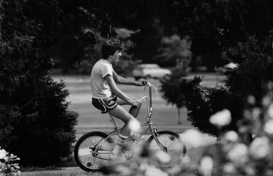 Juli 1978 Ein von Bäumen umrahmter Radfahrer fährt unter strahlendem Sommerhimmel durch einen Park in Denver. (Denver Post über Getty Images)