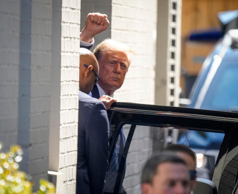 Former President Donald Trump raises his fist as he departs the Capitol Hill Club after meeting with congressional House Republicans on June 13, 2024, in Washington, D.C.