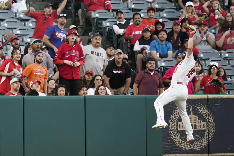 Fans watch as Los Angeles Angels' Brandon Marsh catches a ball hit by Houston Astros' Jose Altuve during the third inning of a baseball game Tuesday, July 12, 2022, in Anaheim, Calif. (AP Photo/Jae C. Hong)