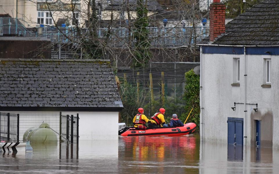 South Wales Fire and Rescue take a resident through floodwaters in Monmouth, - AFP