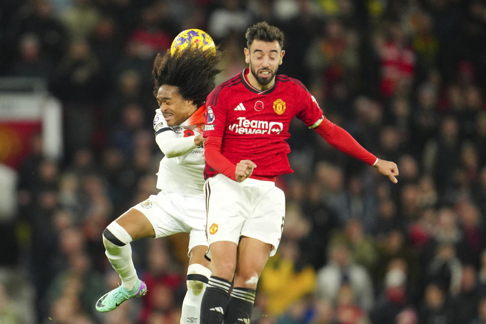 Luton Town's Tahith Chong, left, challenges for the ball with Manchester United's Bruno Fernandes during the English Premier League soccer match between Manchester United and Luton Town at the Old Trafford stadium in Manchester, England, Saturday, Nov. 11, 2023. (AP Photo/Jon Super)