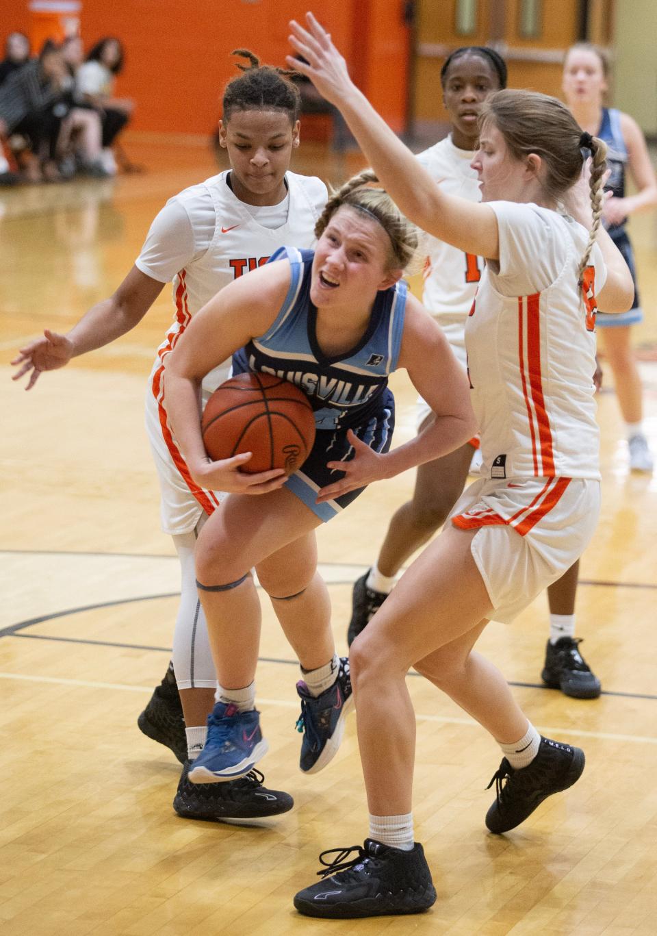 Louisville's Brooke Haren splits the defense of Massillon's Lania Moore, left, and Kylee Hardesty in the second half at Massillon Thursday, January 5, 2023.