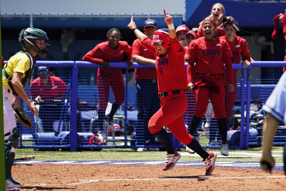 United States' Haylie McCleney scores the game winning run in front of Australia's Belinda White, left, in the eighth inning of a softball game at the 2020 Summer Olympics, Sunday, July 25, 2021, in Yokohama, Japan. (AP Photo/Sue Ogrocki)