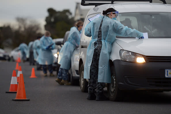 Members of the Australian Defence Force (ADF) gather information and conduct temperature checks at a drive-in Covid-19 testing site set up at the Melbourne Show Grounds in Melbourne.
