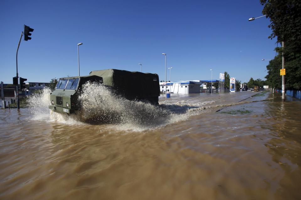 Serbian army soldiers drive through the flood waters in the town of Obrenovac