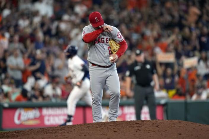 Los Angeles Angels' Aaron Loup wipes his face after giving up a home run to Houston Astros' Chas McCormick during the seventh inning of a baseball game Saturday, July 2, 2022, in Houston. (AP Photo/David J. Phillip)