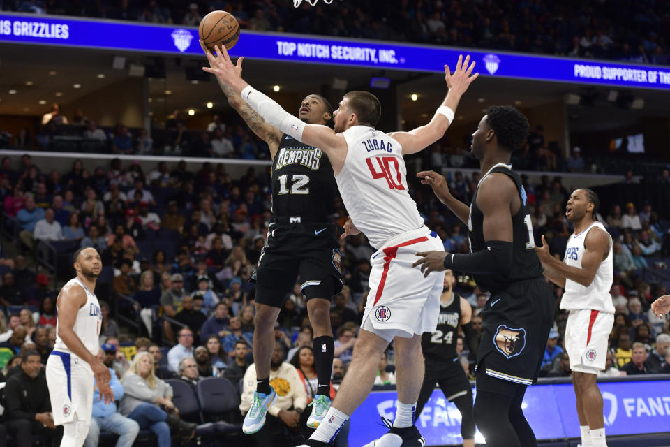Memphis Grizzlies guard Ja Morant (12) shoots against Los Angeles Clippers center Ivica Zubac (40) in the first half of an NBA basketball game Friday, March 31, 2023, in Memphis, Tenn. (AP Photo/Brandon Dill)