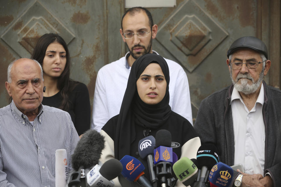 Palestinian activist Muna al-Kurd, center, speaks at a press conference in the Sheikh Jarrah neighborhood of east Jerusalem, with her father, right, and neighbors, Nov. 2, 2021. Palestinian families in the tense neighborhood of Jerusalem have rejected an offer that would have delayed their eviction by Jewish settlers. In a statement on Tuesday, the four families said their decision springs from "our belief in the justice of our cause and our right to our homes and our homeland." (AP Photo/Mahmoud Illean)