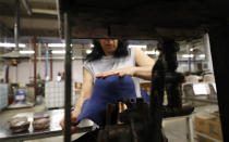 A woman moulds a hat inside Borsalino's hat factory, in Spinetta Marengo, near Alessandria, Italy, Thursday, Jan. 17, 2019. Borsalino's prized felt hats are handmade by 80 workers in its Piemonte factory, many who have worked there for decades, with original machinery that use hot water and steam to transform rabbit fur into highly prized felt, that is formed into clochards, dyed and molded by hand to create the latest styles. (AP Photo/Antonio Calanni)