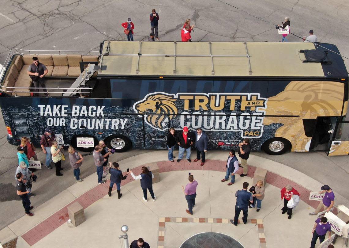 People lined up to have a photo taken with Sen. Ted Cruz and Amanda Adkins, the Republican candidate in Kansas’ 3rd Congressional District, during a stop Friday, Oct. 14, 2022, in Ottawa, Kansas.