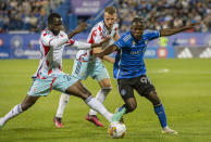 Chicago Fire's Ousmane Doumbia (26) and Kendall Burks, center, pressure CF Montreal's Kwadwo Opoku (90) during the second half of an MLS soccer match in Montreal, Saturday, Sept. 16, 2023. (Peter McCabe/The Canadian Press via AP)