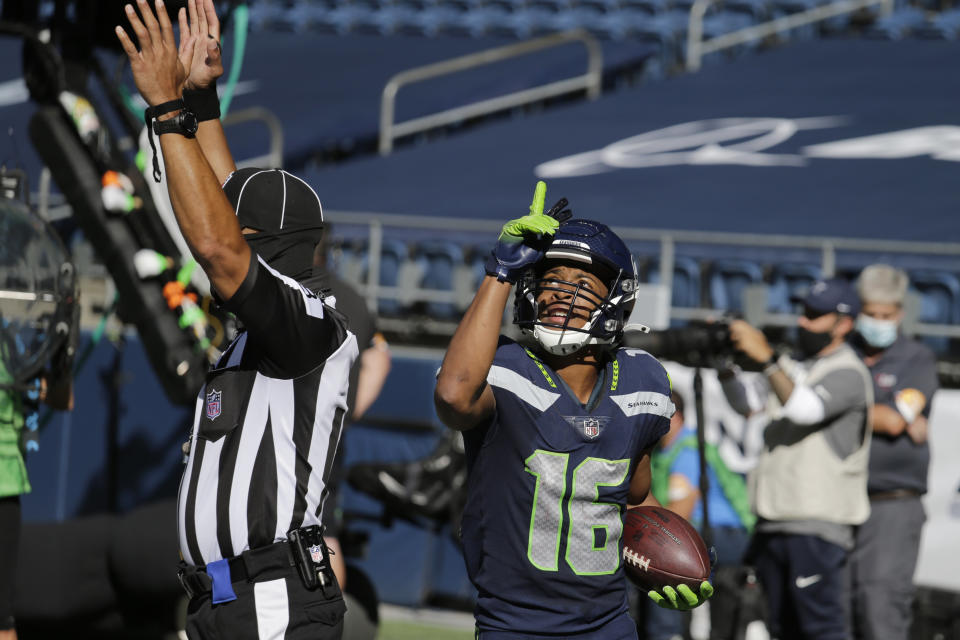 Seattle Seahawks wide receiver Tyler Lockett holds the ball and reacts after scoring a touchdown against the Dallas Cowboys during the first half of an NFL football game, Sunday, Sept. 27, 2020, in Seattle. (AP Photo/John Froschauer)