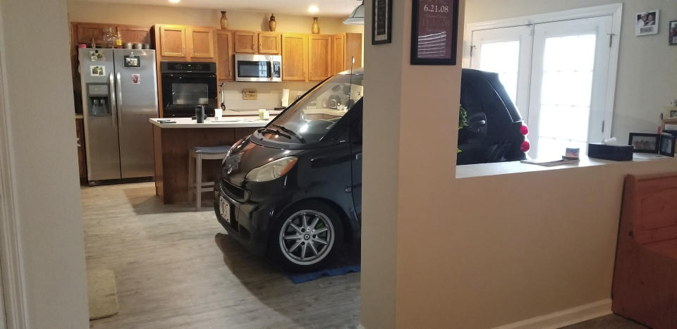 In this Sept. 3, 2019 photo provided by Jessica Eldridge, her husband's Smart car is parked in their kitchen in Jacksonville, Fla. Patrick Eldridge parked his Smart car in his kitchen to protect it from Hurricane Dorian. In a Facebook post, Jessica Eldridge said her husband was "afraid his car might blow away" so he parked it in their Jacksonville home's kitchen. The story was among Florida's top odd stories for 2019. (Jessica Eldridge via AP)