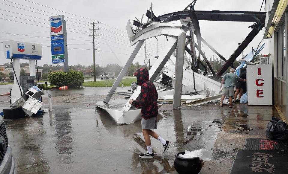 People stock up on ice and other items at a damaged convenience store after Hurricane Sally passed near Spanish Fort, Alabama.