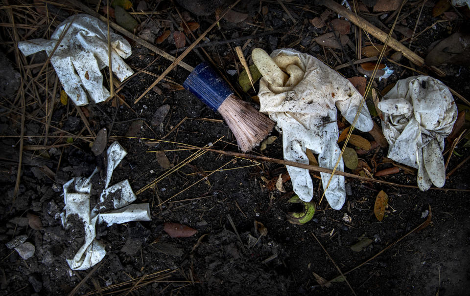 A shaving brush and gloves of deceased COVID-19 victims and their relatives lie in a cremation ground in Gauhati, India, Friday, July 2, 2021. The personal belongings of cremated COVID-19 victims lie strewn around the grounds of the Ulubari cremation ground in Gauhati, the biggest city in India’s remote northeast. It's a fundamental change from the rites and traditions that surround death in the Hindu religion. And, perhaps, also reflects the grim fears grieving people shaken by the deaths of their loved ones — have of the virus in India, where more than 405,000 people have died. (AP Photo/Anupam Nath)