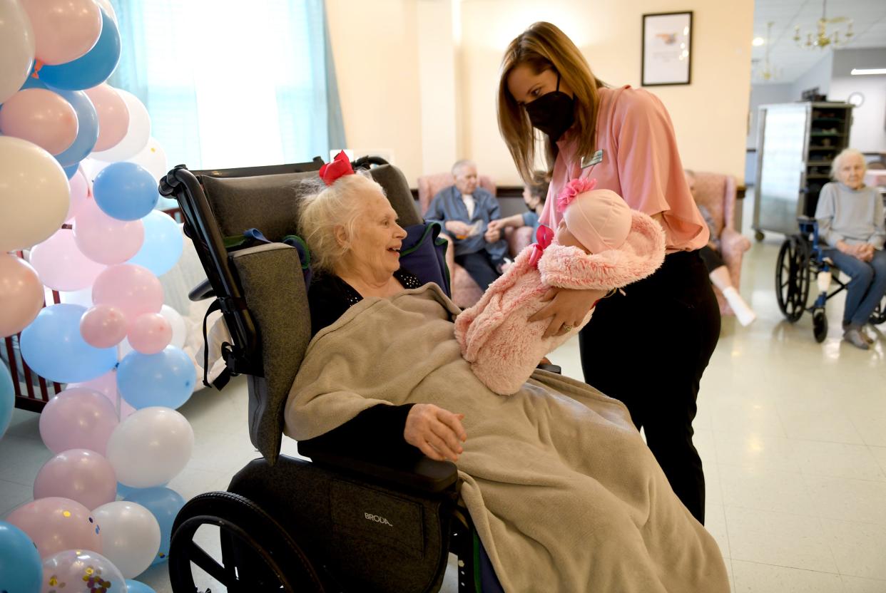 Glenwood Care and Rehabilitation Activities Director Krystal Hanze introduces resident Carolyn Kramerage to a life-like doll during a "baby shower" at the Canton facility. Memory-care residents received dolls donated by Pearl's Memory Babies.